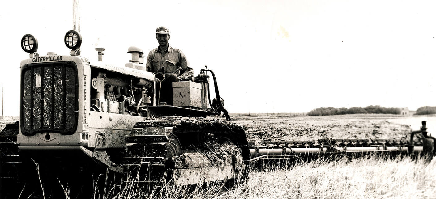 Black and white photo of a farmer operating a harvester