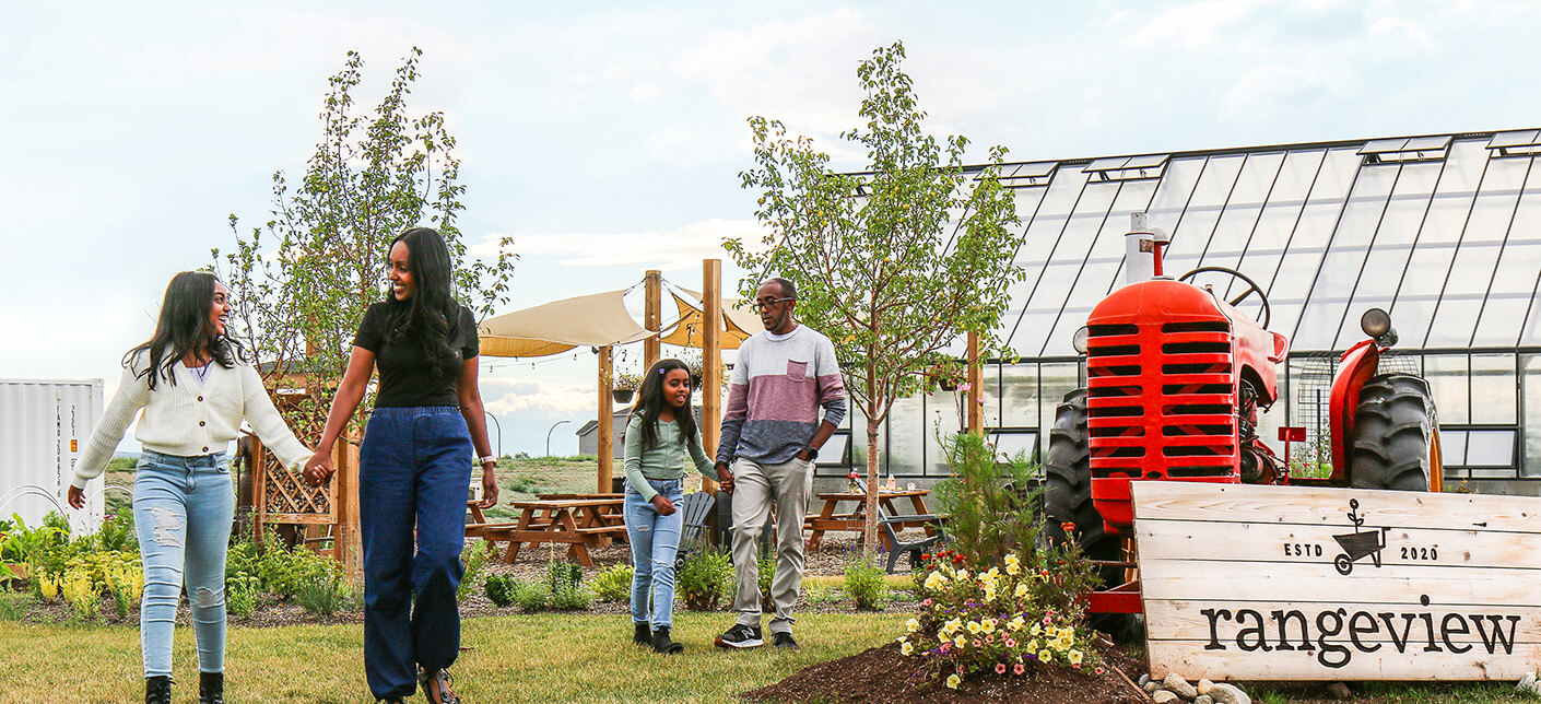 Family holding hands and walking in front of a sign for the Community of Rangeview