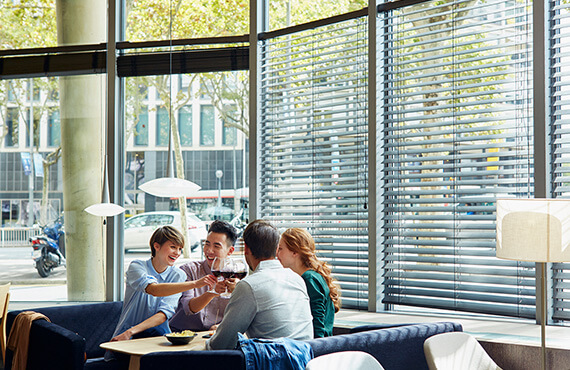 Group of 4 friends sitting in a restaurant raising a toast